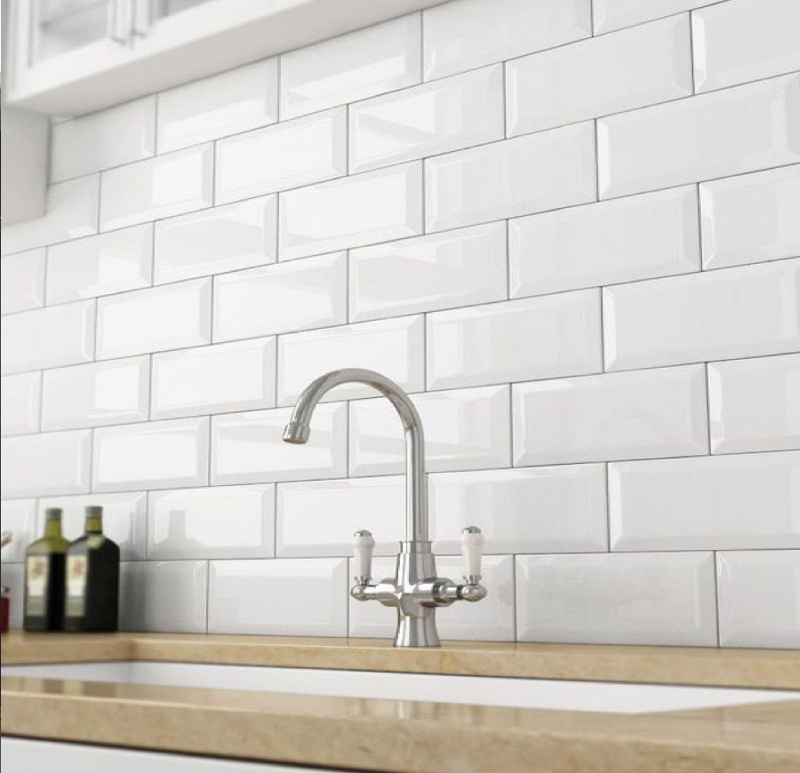 Detail of white bevelled Balena subway tiles above a basin