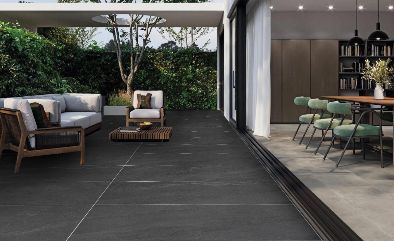 Open-plan living and dining space with a dark large-format Balena floor running out to a terrace