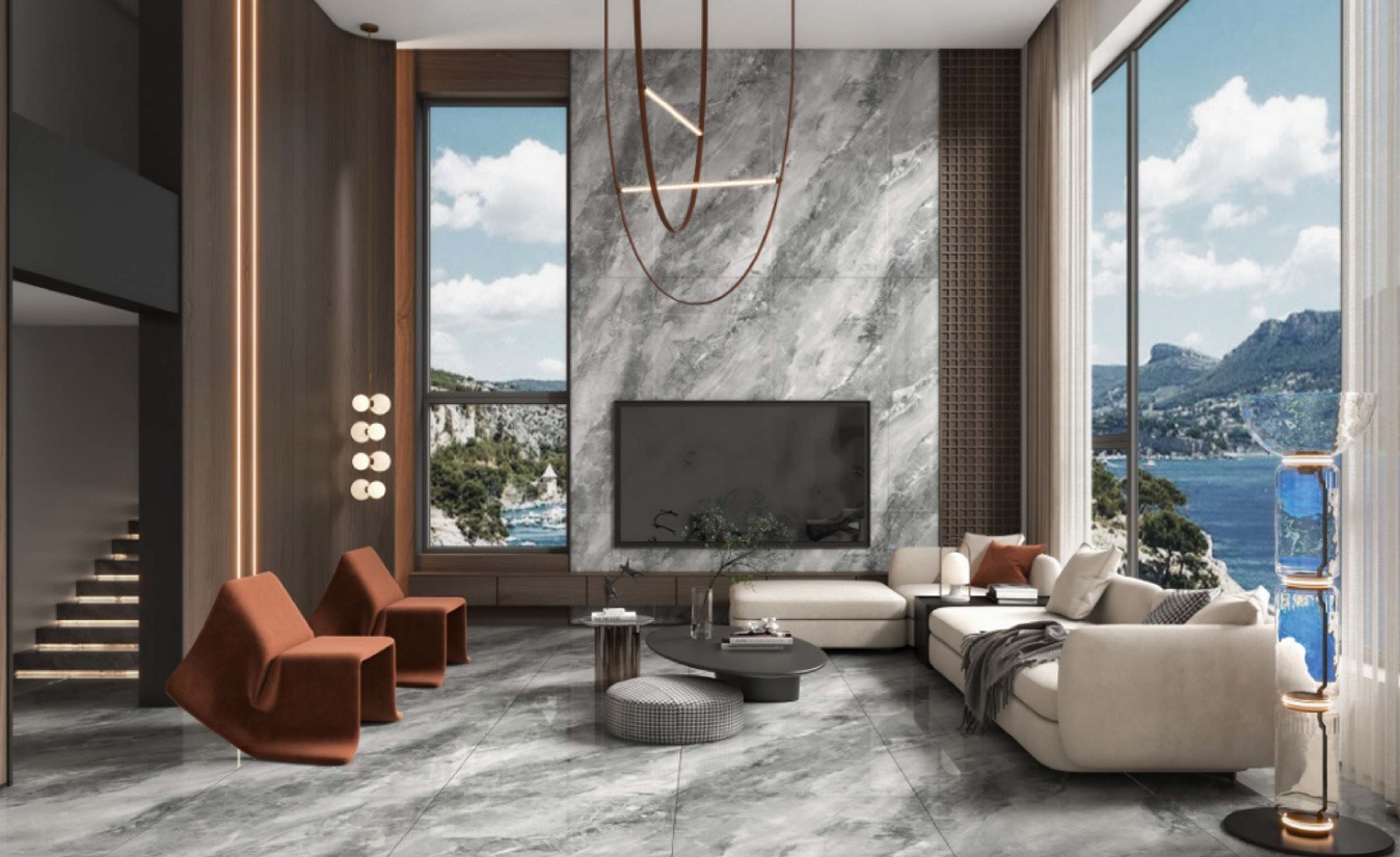 Living room finished in large-format Balena marble-look porcelain across the wall and floor, opening to a sea view