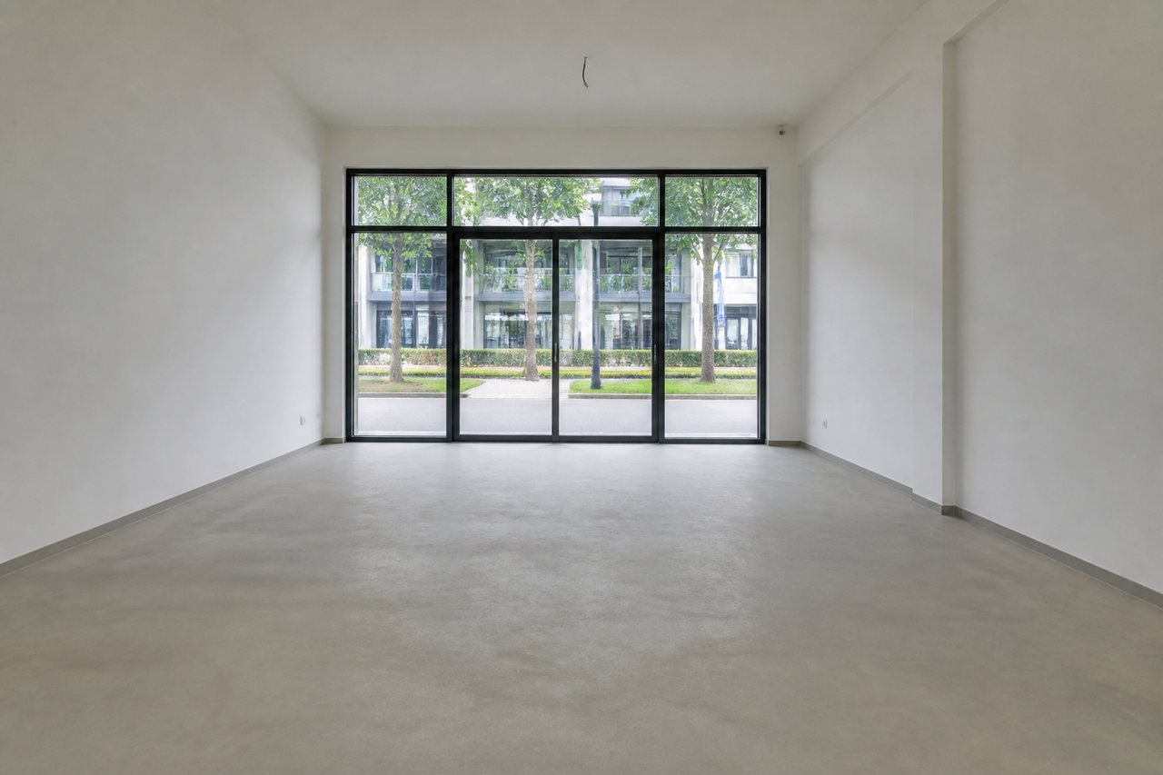 Empty room with a plain screed floor, before tiling